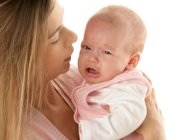 Новорождённый ребёнок плачет на руках у мамы
