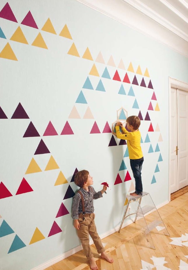 Украшение белой стены детской разноцветными треугольниками