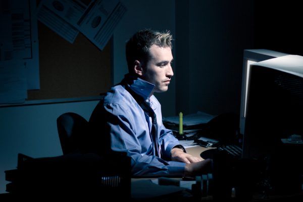 Мужчина сидит за компьютером ночью